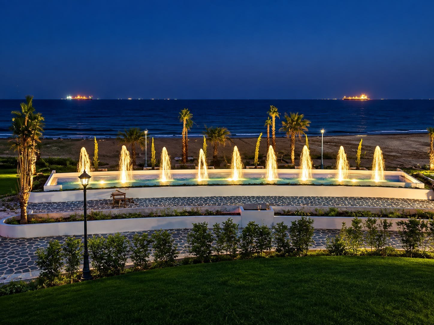 Night fountain installation by the sea